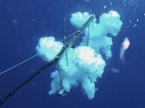 The two guns behind the ship fire bubbles into the water. The bubbles take a three-dimensional clover shape before dissipating and rising to the surface.