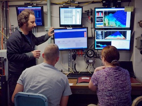 Ashley, Tom, and Steve look at five screens of real-time geophysical data they try to keep track of as Watchstanders.
