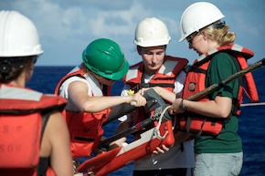 Dr. Oakley, Jen Herting, and Bridget Hass work to secure a floatation device to the seismic cable.